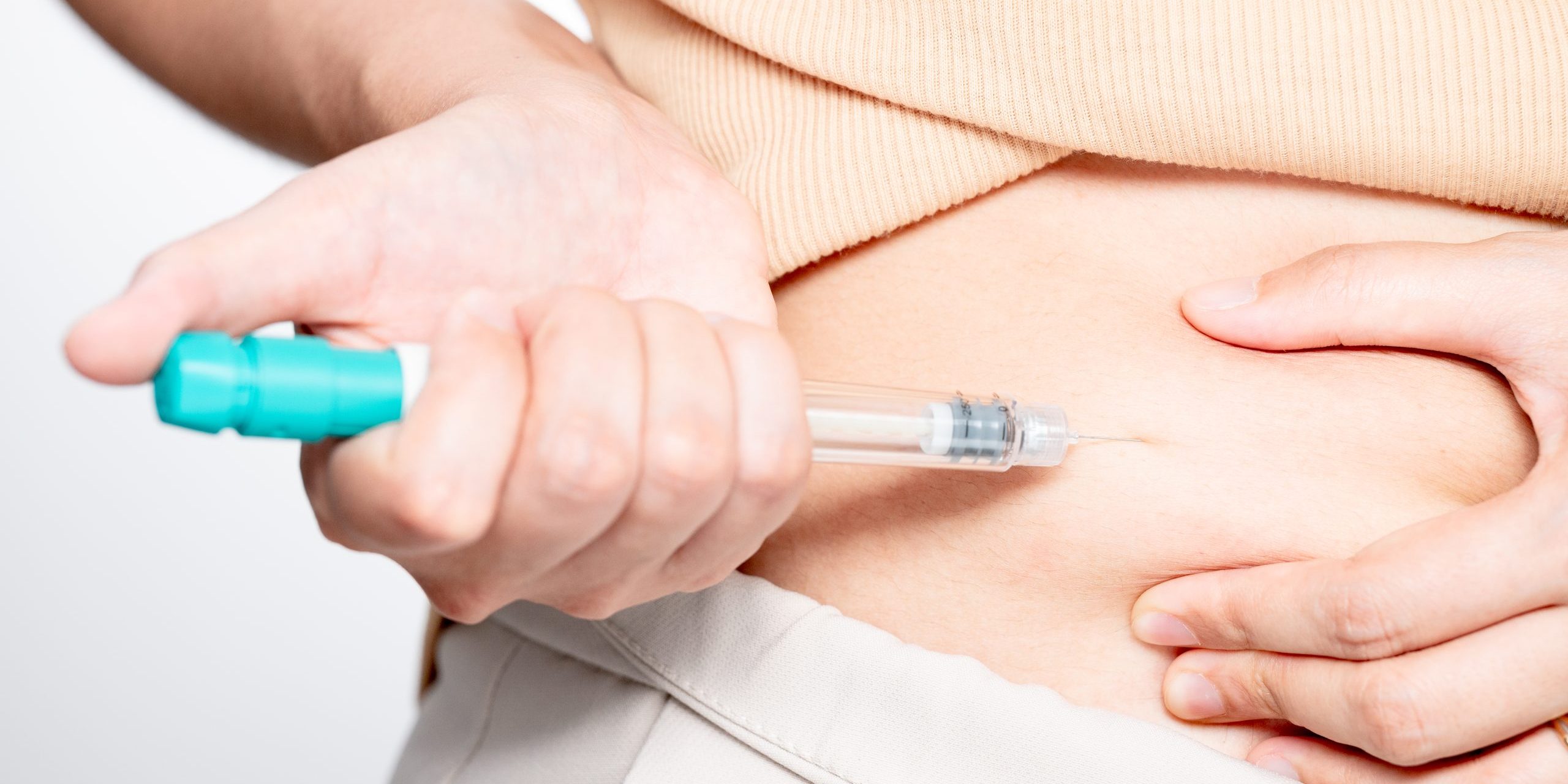 Woman making hormonal therapy injection into her belly. Close up